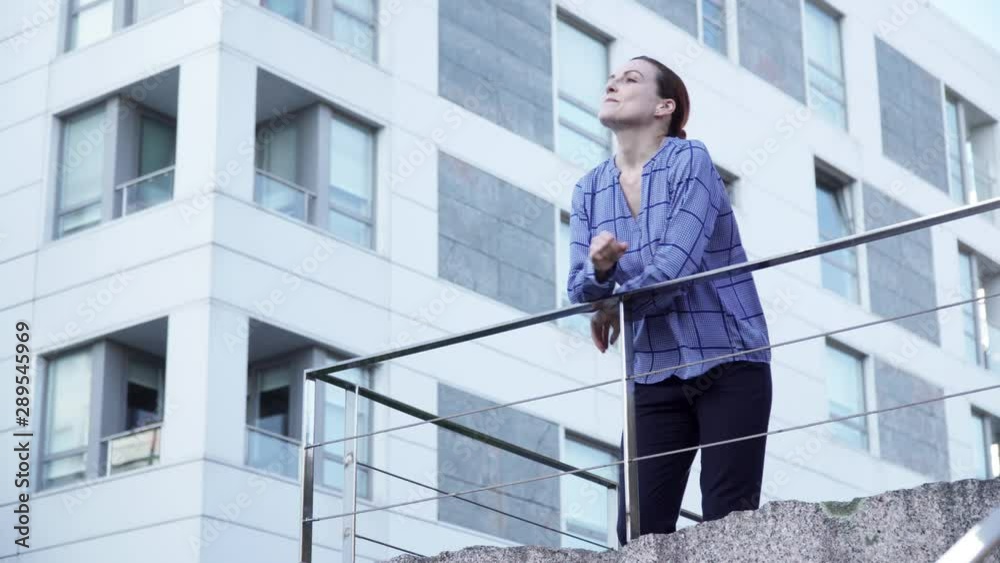 Serious businesswoman leaning on railing
