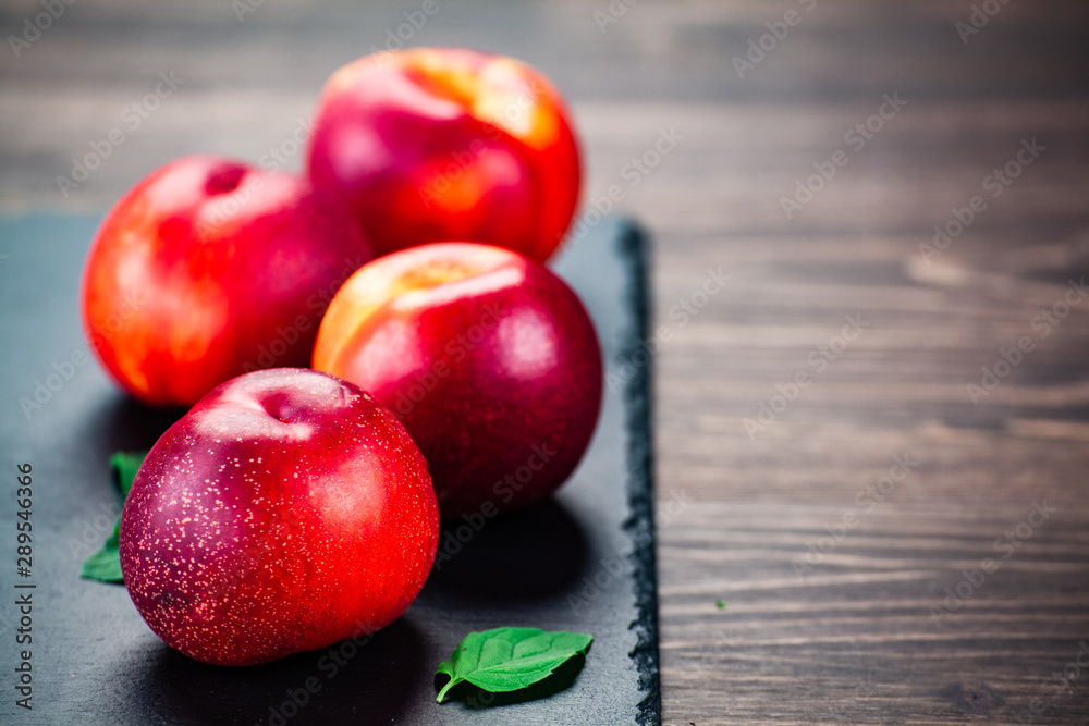 Plums on black stone plate