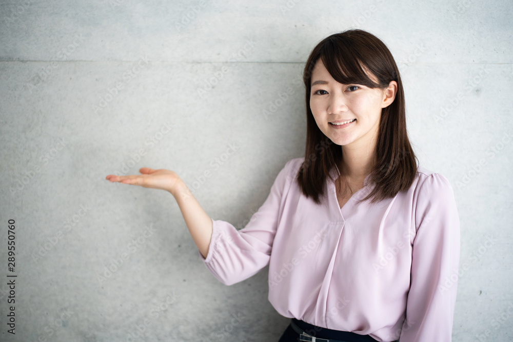 Young business woman explaining against concrete wall Young business woman explaining against concrete wall