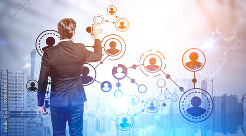 Businessman drawing social network icons in city photo
