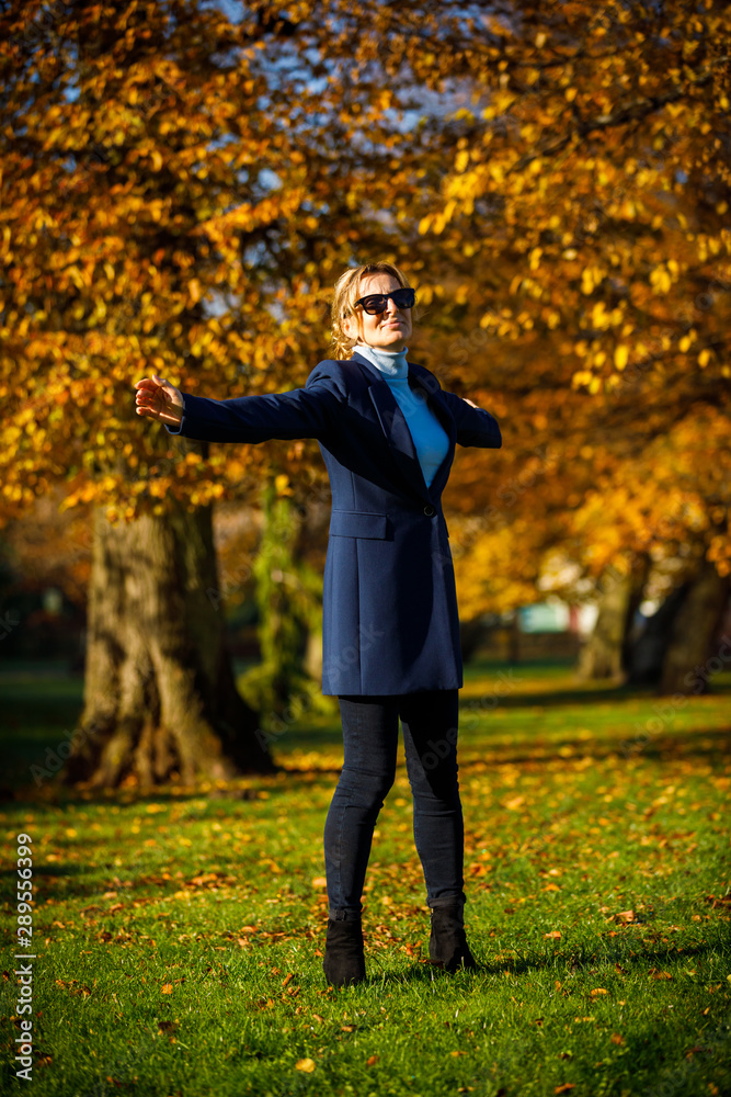 Middle-aged woman walking in city park Middle-aged woman walking in city park