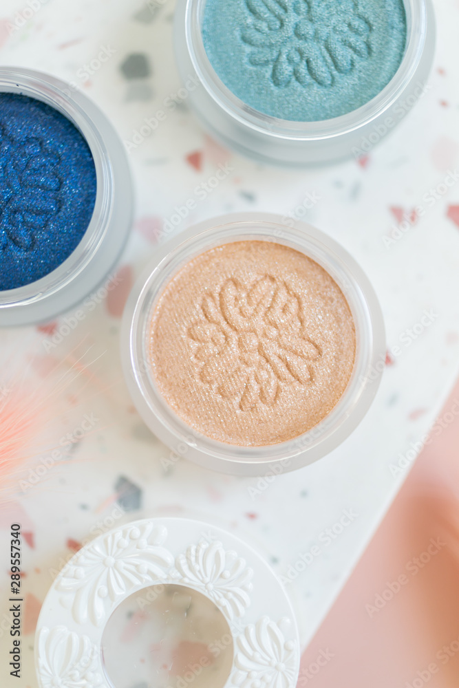 Eyeshadow pots on terrazzo dish, pink background, styled with dried plants, women's makeup flat lay Eyeshadow pots on terrazzo dish, pink background, styled with dried plants, women's makeup flat lay