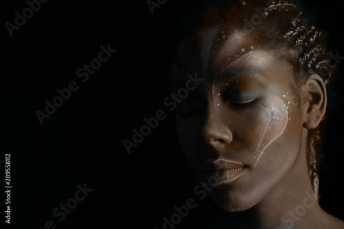 Art photo of Africal woman with tribal ethnic paintings on her face photo