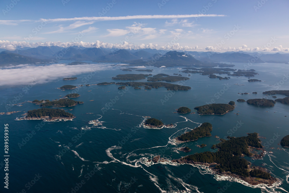 Aerial Landscape View of Beautiful Pacific Ocean Coast with Coastal Mountains at the background during a summer morning. Taken near Tofino and Ucluelet, Vancouver Island, British Columbia, Canada.