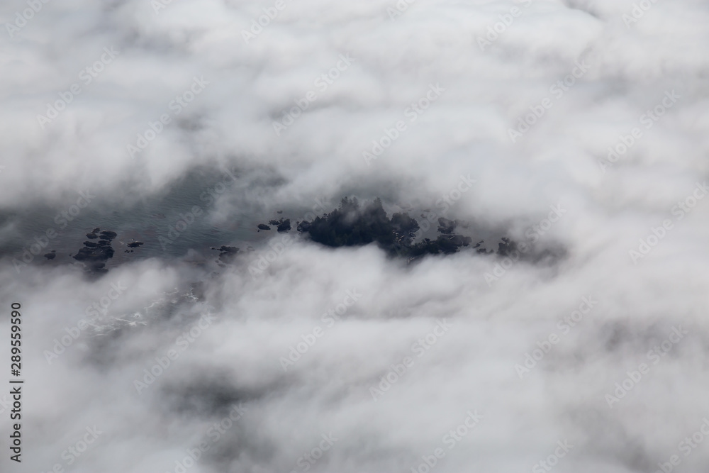 Aerial View from Above of a beautiful rocky beach covered in Clouds and Fog at the West Pacific Ocean Coast. Taken near Tofino and Ucluelet in Vancouver Island, BC, Canada.