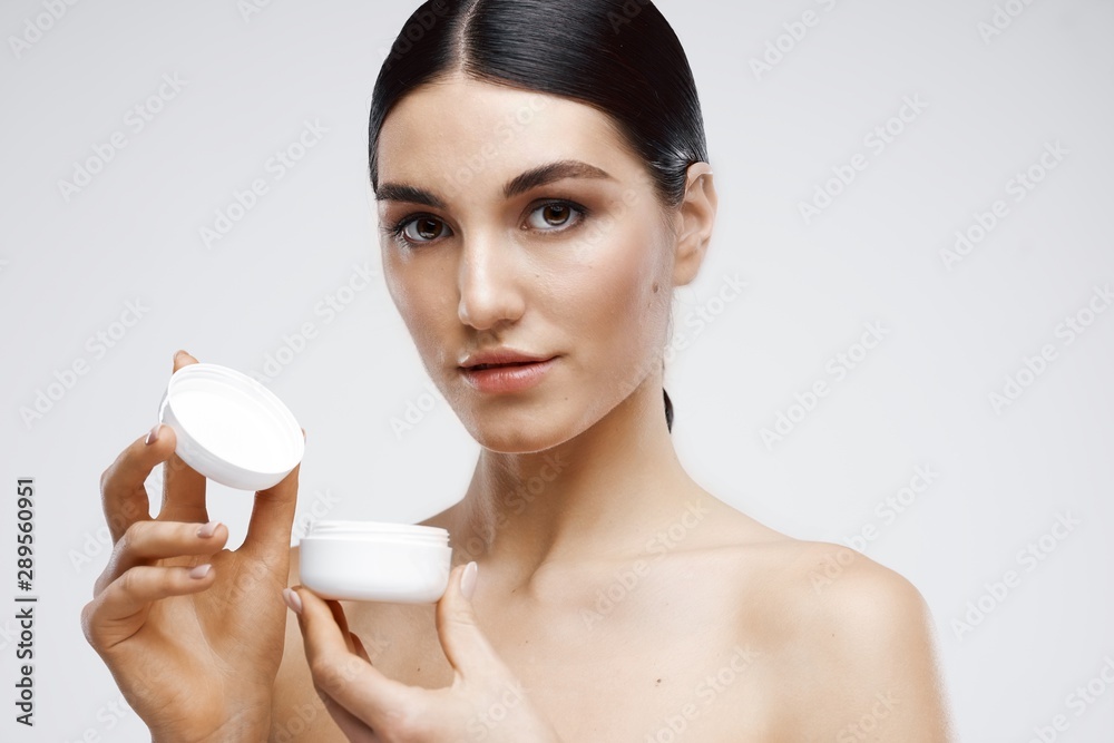 woman applying cream on her face woman applying cream on her face
