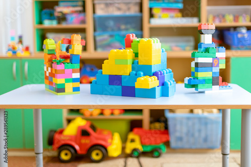 toy cars on the table.Children's playroom with plastic colorful educational blocks toys. Games floor for preschoolers kindergarten. interior children's room. Free space.  © Delete