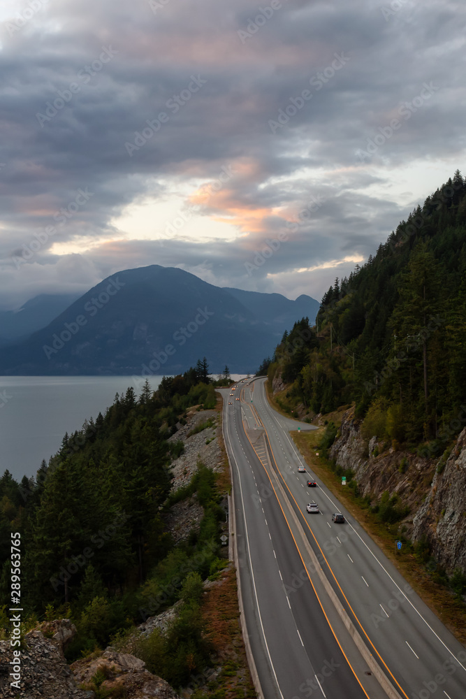 Fototapeta premium Beautiful Aerial View of Sea to Sky Highway in Howe Sound during a colorful summer sunset. Taken North of Vancouver, British Columbia, Canada.