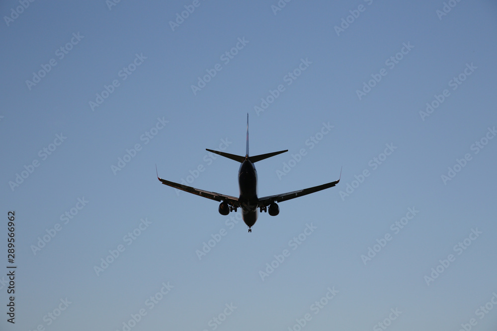 Airplane in a blue clear sky. The plane takes off or lands for landing. Air passenger transport. Airplane in a blue clear sky. The plane takes off or lands for landing. Air passenger transport.
