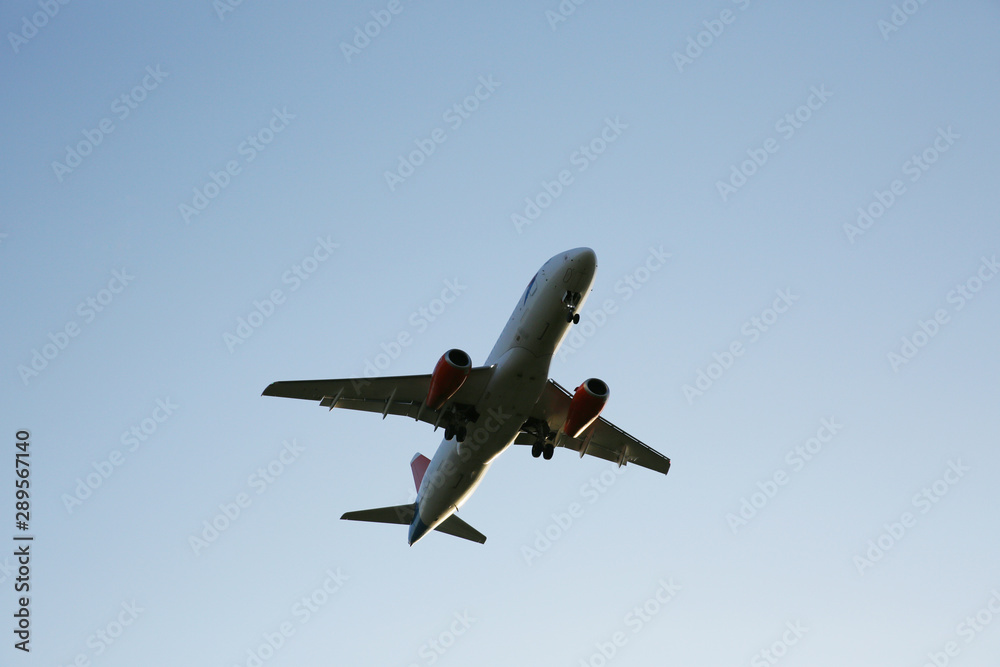 dark silhouette of airplane flying on the blue sky. With copy space for text or image. Close-up. Air passenger transport. dark silhouette of airplane flying on the blue sky. With copy space for text or image. Close-up. Air passenger transport.