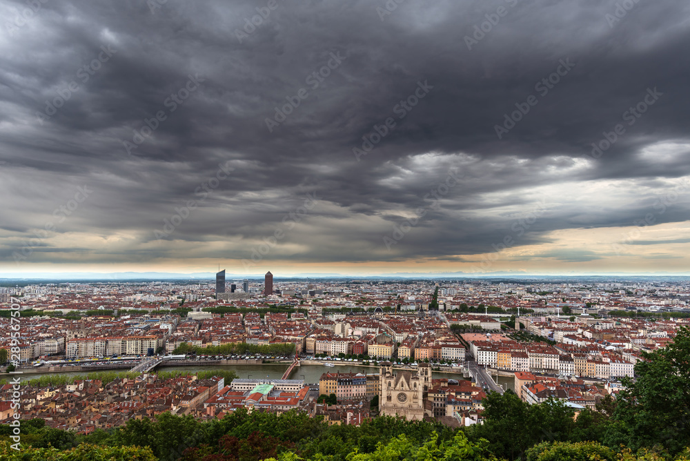 Panorama of the city of Lyon, France, under a menacing sky full of dark gray clouds