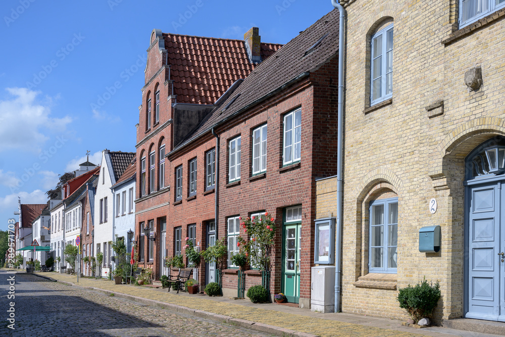 street with cobblestone pavement and roses  in Friedrichstadt, the beautiful town and travel destination in northern Germany founded by Dutch settlers
