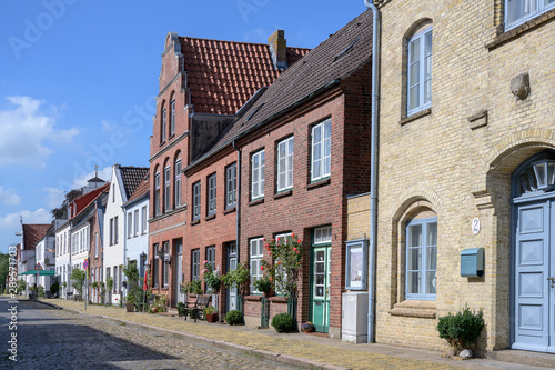 street with cobblestone pavement and roses in Friedrichstadt, the beautiful town and travel destination in northern Germany founded by Dutch settlers