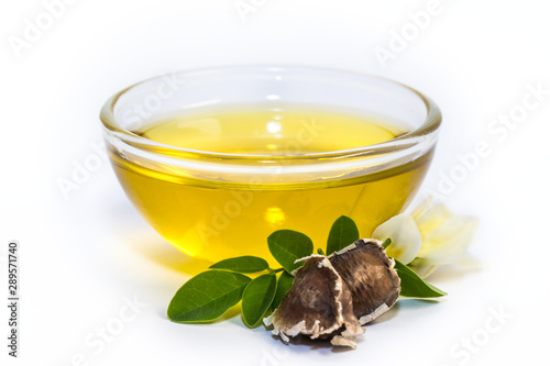 Moringa oleifera oil with seeds and leawes. Isolated on white background.