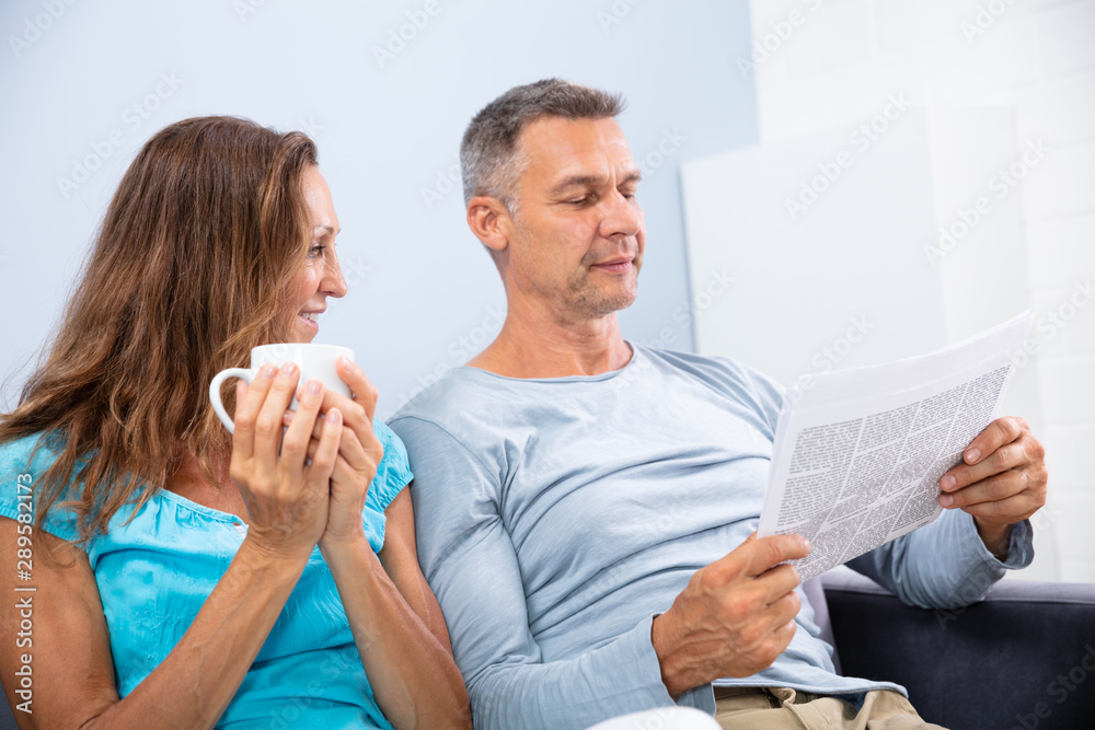 Couple Reading Newspaper At Home Couple Reading Newspaper At Home