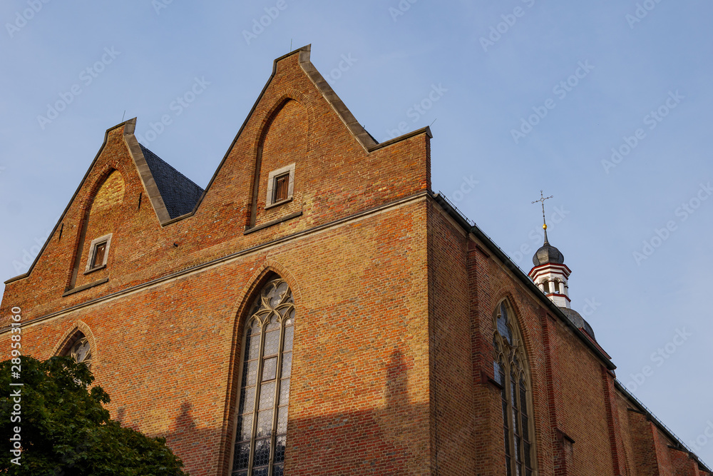 Low angle exterior view of old brick monastery church, Kreuzherrenkirche , on the oldest historical street, Ratinger Street, in Düsseldorf, Germany.