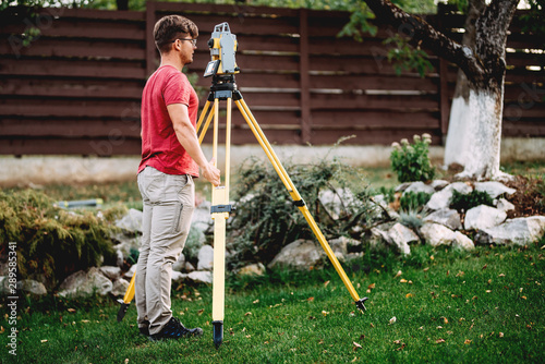Portrait of surveyor engineer working with total station theodolite and gps system