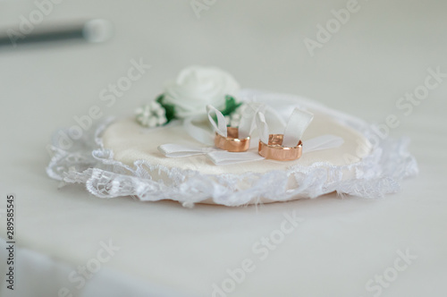 Couple of gold wedding rings on the white pad