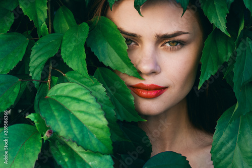 Woman with red lips green leaves