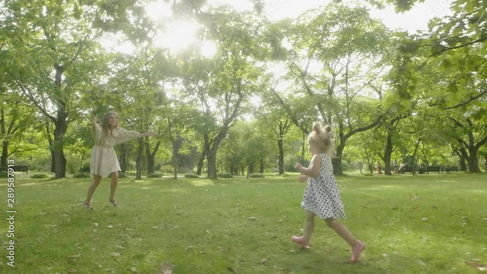 Baby girl with mother running through the grass in the summer sunlight in park. Baby have fun. Happy family concept. Child with mother running. Baby girl with mother running through the grass in the summer sunlight in park. Baby have fun. Happy family concept. Child with mother running.