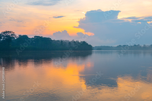 Sunset with pastel colors and fog in the Amazon River Basin inside the Cuyabeno Wildlife Reserve, Ecuador. photo