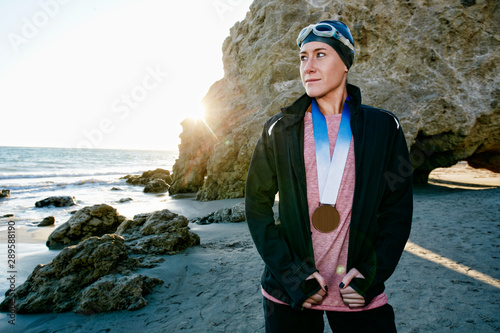 Swimmer on beach with medal