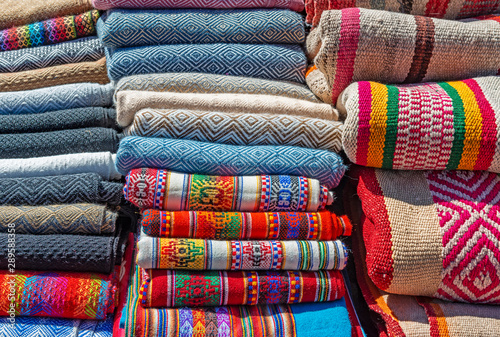 A pile of traditional Andes textiles in alpaca wool and cotton on a Sunday market in Cusco, Peru.