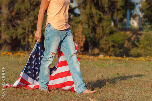 Woman with a flag of United States of America in the hands, outdoors