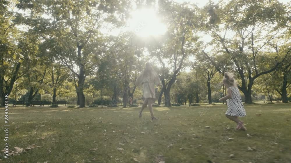 Child with mother running. Baby girl with mother running through the grass in the summer sunlight in park. Baby have fun. Happy family concept. Child with mother running. Baby girl with mother running through the grass in the summer sunlight in park. Baby have fun. Happy family concept.