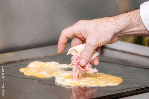 Chef cooking delicious Omelette with ham and cheese .