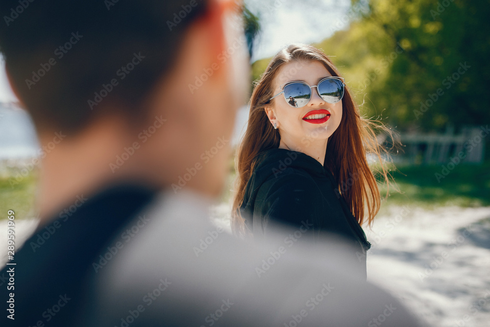 A stylish and bright love couple walks on the sunny beach