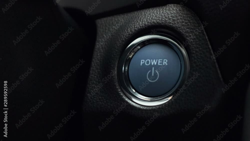 pushing blue  power ignition button to start keyless ignition hybrid car engine