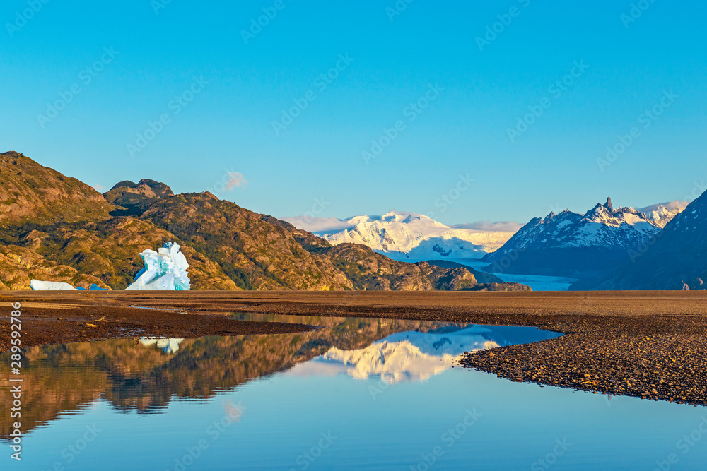 Landscape inside of Torres del Paine national park at sunrise by Lago Grey with the Grey Glacier in the background and large icebergs, Puerto Natales, Patagonia, Chile.