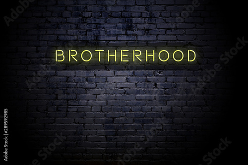 Highlighted brick wall with neon inscription brotherhood photo