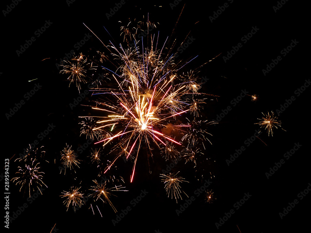 sparkling golden and violet fireworks at night