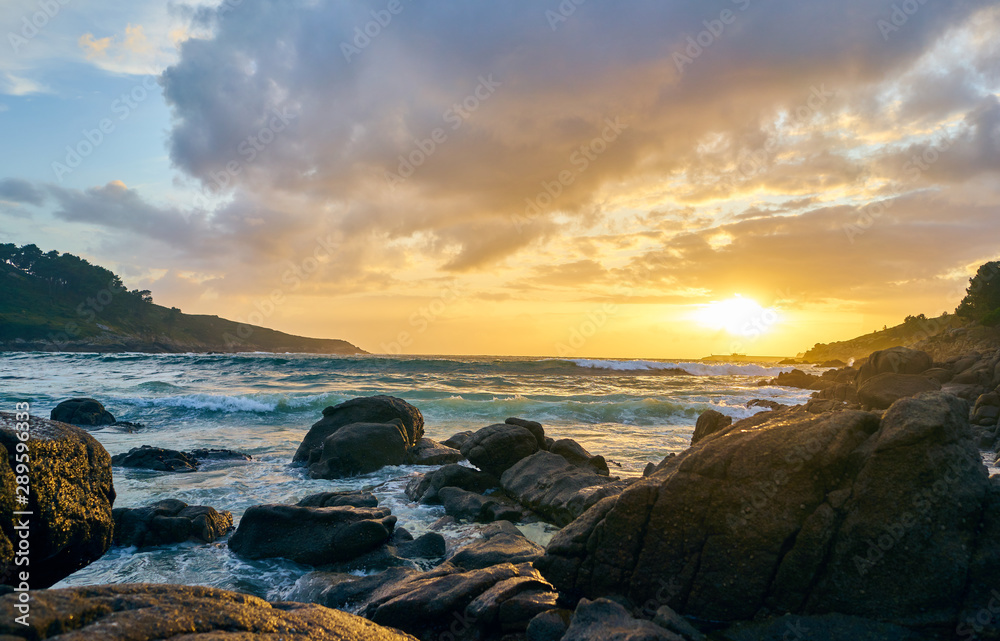 Sunset of the sea with rocks and mountain in the background. Beach ...