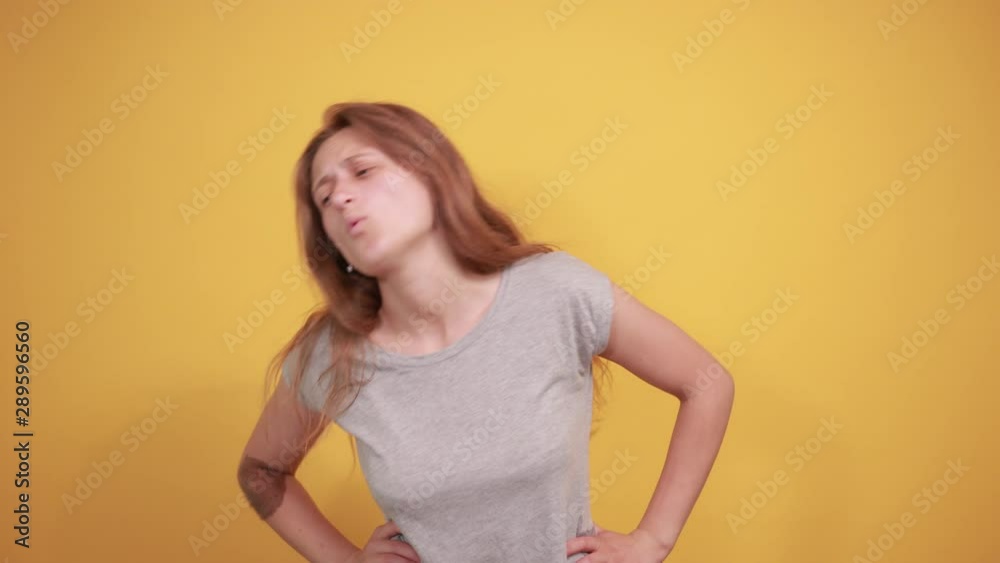 brunette girl in gray t-shirt over isolated orange background shows emotions brunette girl in gray t-shirt over isolated orange background shows emotions