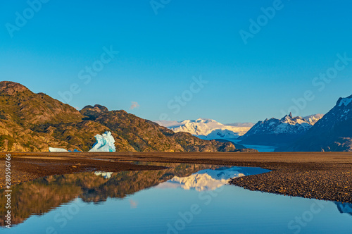 Landscape inside of Torres del Paine national park at sunrise by Lago Grey with the Grey Glacier in the background and large icebergs, Puerto Natales, Patagonia, Chile.