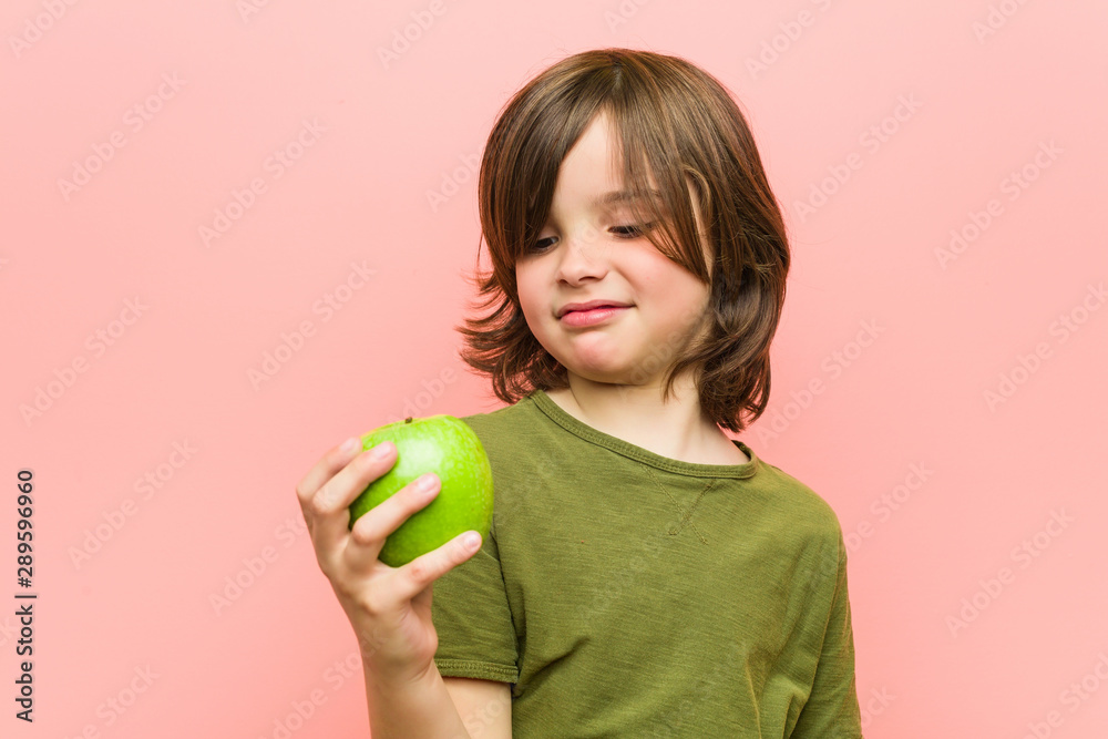 Little caucasian boy holding an apple Little caucasian boy holding an apple