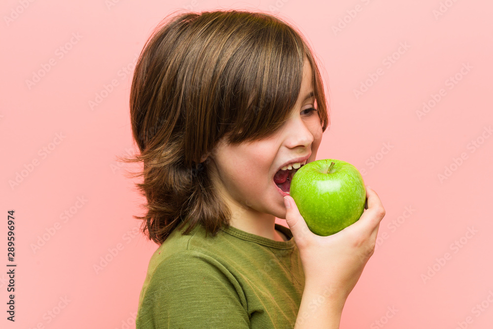 Little caucasian boy holding an apple