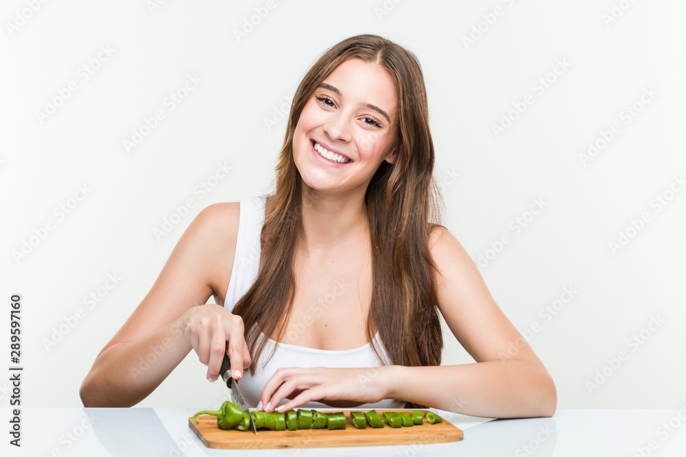 young caucasian woman cutting vegetables