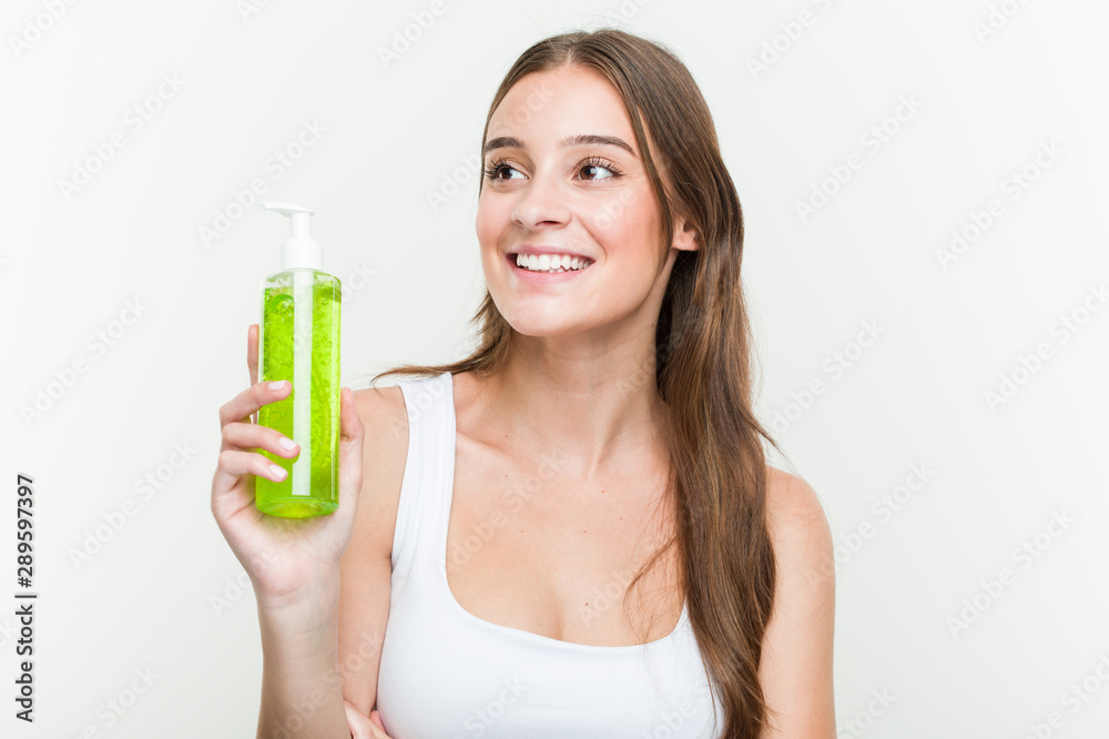 Young caucasian woman holding an aloe vera bottle smiling confident with crossed arms. Young caucasian woman holding an aloe vera bottle smiling confident with crossed arms.