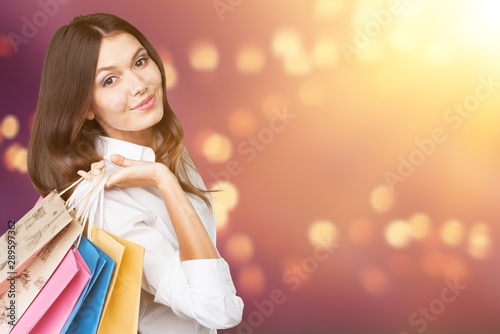 Young woman with shopping bags on blurred shopping mall background