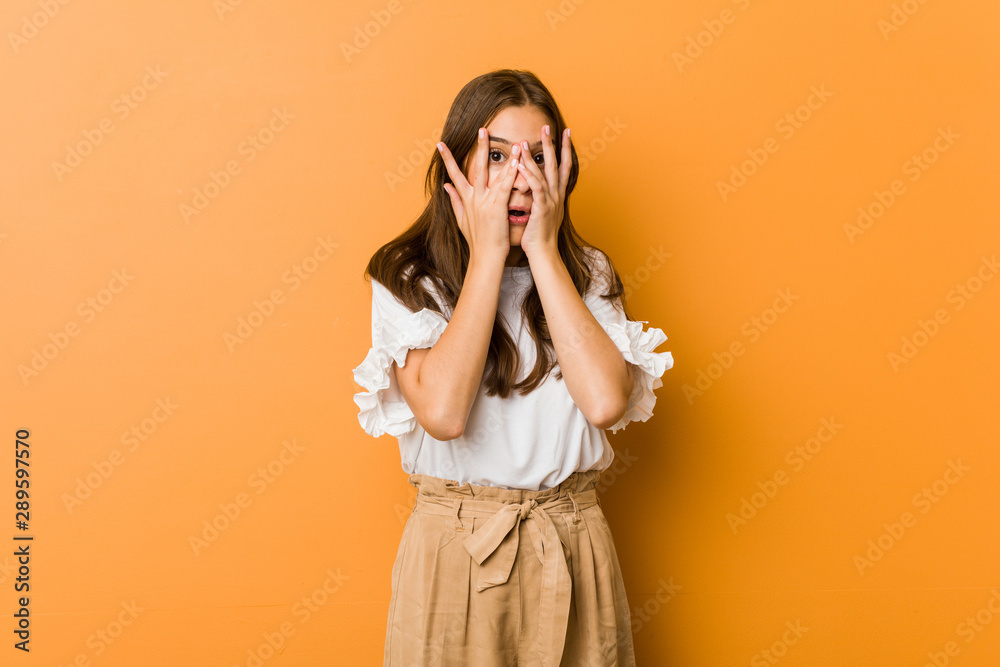 Young caucasian woman blink through fingers frightened and nervous. Young caucasian woman blink through fingers frightened and nervous.