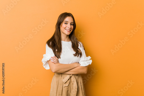 Young caucasian woman smiling confident with crossed arms.