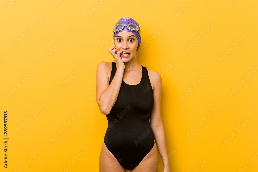 Young swimmer caucasian woman biting fingernails, nervous and very anxious. Young swimmer caucasian woman biting fingernails, nervous and very anxious.