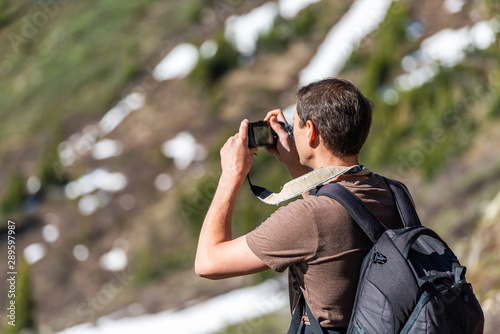 Man taking pictures of view on Linkins Lake trail on Independence Pass in rocky mountains near Aspen, Colorado in early summer of 2019 with snow background © Kristina Blokhin
