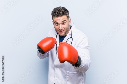 Caucasian doctor man wearing boxing gloves © Asier