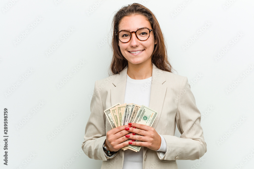 Young european business woman holding dollar banknotes happy, smiling and cheerful. Young european business woman holding dollar banknotes happy, smiling and cheerful.