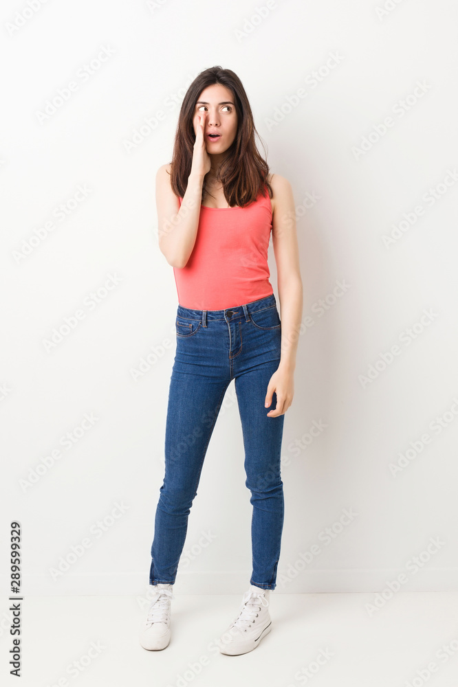 Full body young woman on white background is saying a secret hot braking news and looking aside Full body young woman on white background is saying a secret hot braking news and looking aside